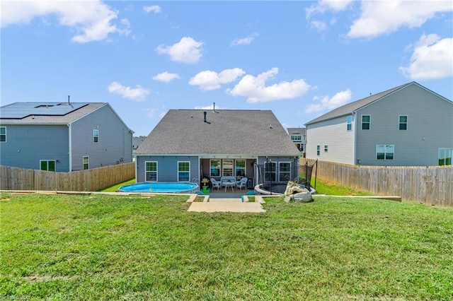 rear view of house featuring a patio, a yard, and a fenced backyard