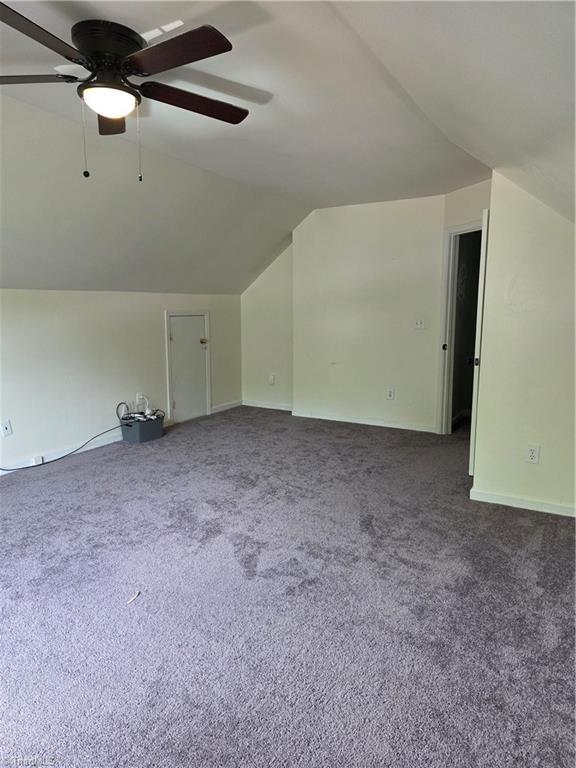 1030 Still Point Dr, Winston-Salem, NC 27103 - additional living space with vaulted ceiling, a ceiling fan, and dark carpet