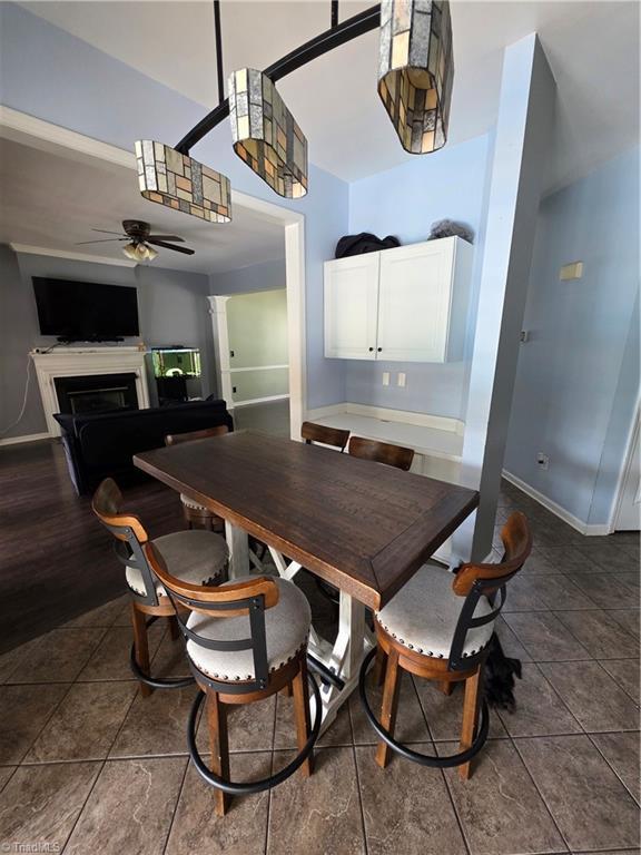 1030 Still Point Dr, Winston-Salem, NC 27103 - tiled dining space featuring a ceiling fan, a fireplace, and baseboards