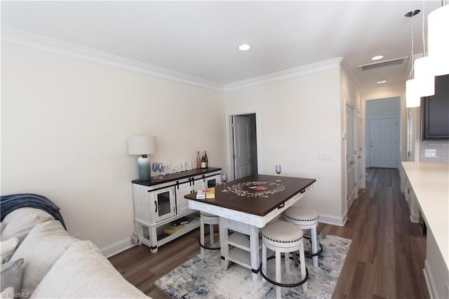 dining area with crown molding and dark wood-type flooring