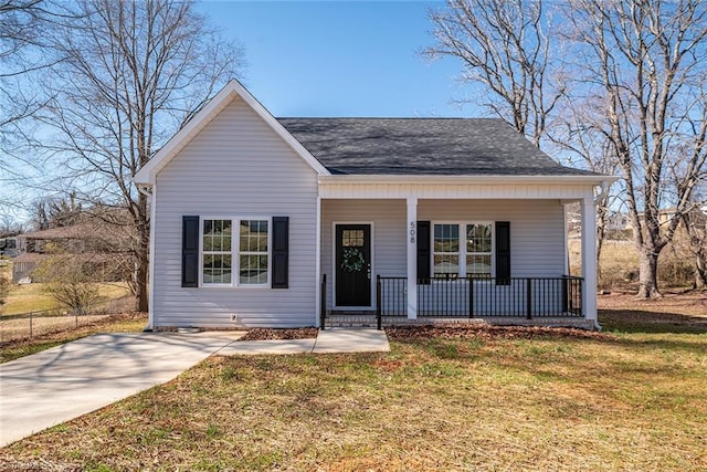 bungalow featuring covered porch, a shingled roof, and a front yard