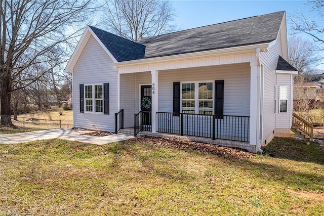 view of front facade featuring covered porch, roof with shingles, and a front yard