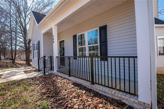 view of property exterior featuring covered porch and roof with shingles