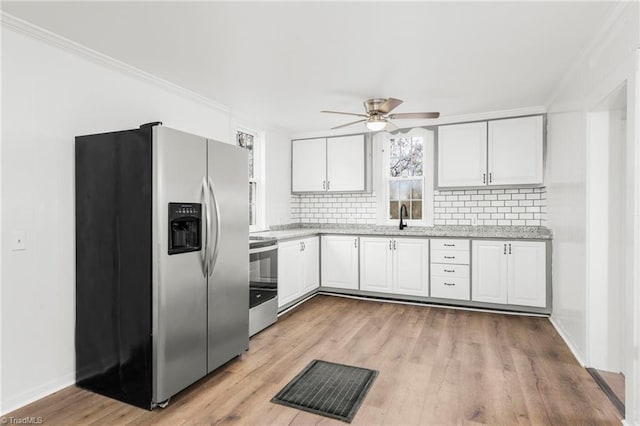 kitchen featuring ceiling fan, white cabinets, light hardwood / wood-style floors, and appliances with stainless steel finishes