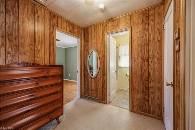 hallway featuring ornamental molding and wood walls