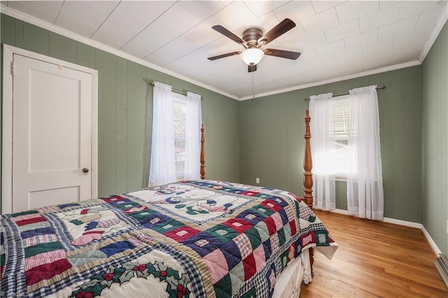 bedroom with light wood-type flooring, ceiling fan, and crown molding