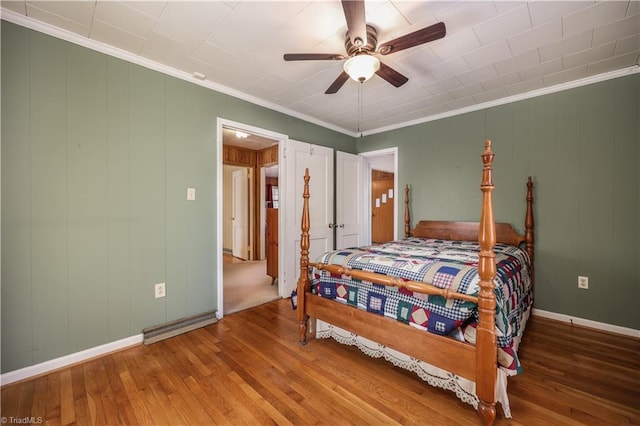 bedroom featuring ceiling fan, wood-type flooring, and crown molding