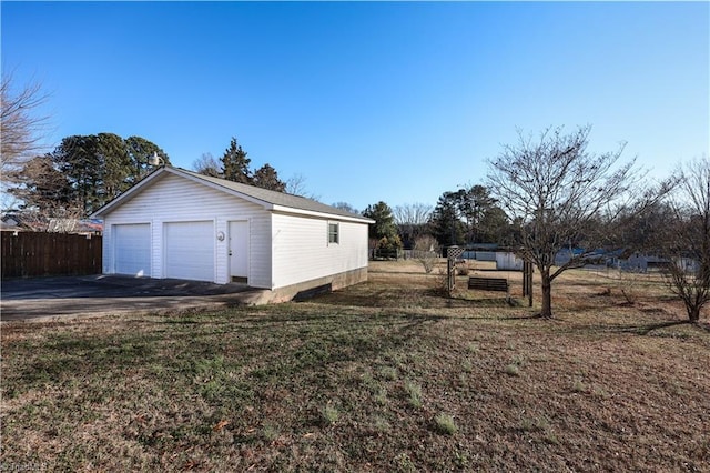 view of side of property with a yard, an outdoor structure, and a garage