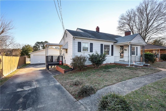 view of front of home featuring a garage, an outdoor structure, and a front lawn