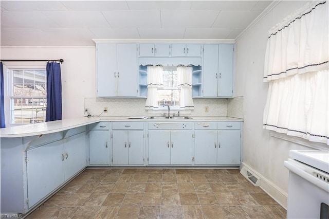 kitchen with decorative backsplash, crown molding, and sink