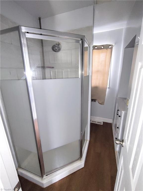 bathroom with wood-type flooring and walk in shower