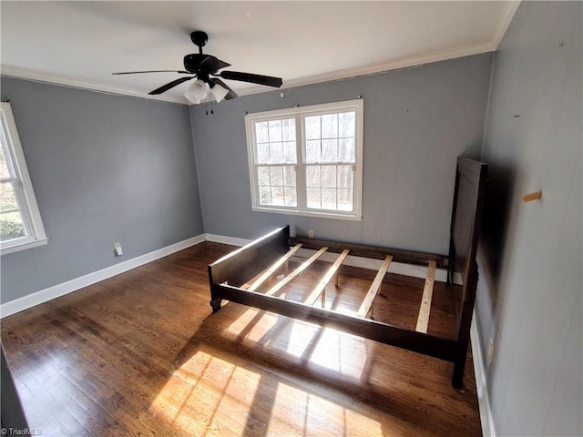 unfurnished bedroom featuring dark hardwood / wood-style flooring, crown molding, multiple windows, and ceiling fan