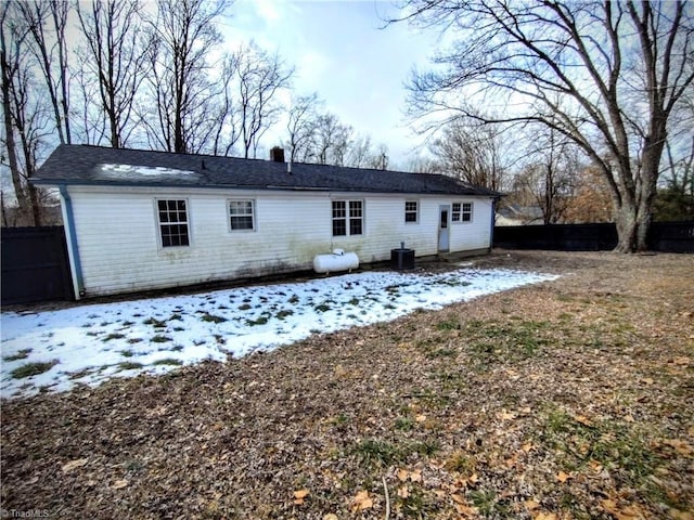 snow covered house with central air condition unit