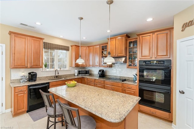 kitchen with a center island, backsplash, hanging light fixtures, and black appliances