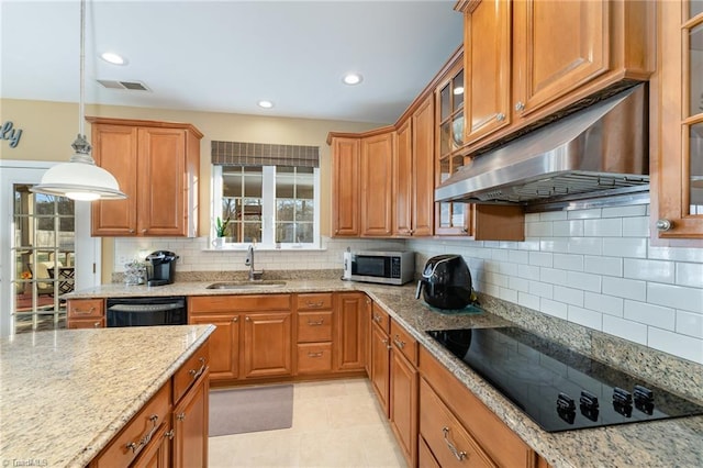 kitchen featuring sink, backsplash, hanging light fixtures, and black appliances