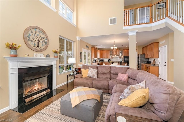 living room with a high ceiling and light hardwood / wood-style flooring