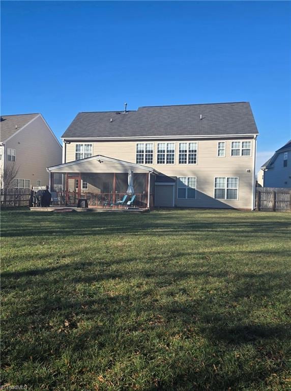 back of house with a sunroom and a yard