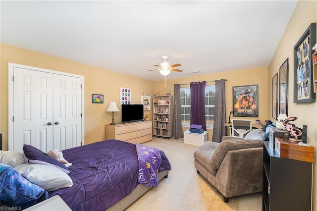 carpeted bedroom featuring ceiling fan and a closet