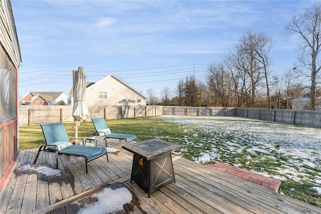 wooden terrace with a fire pit and a lawn