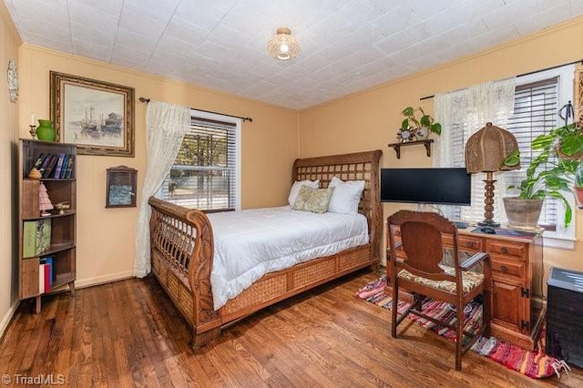 bedroom with dark wood-type flooring and crown molding