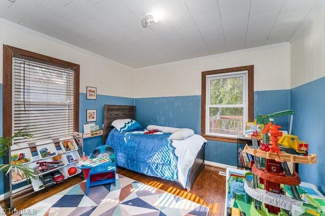 bedroom with ornamental molding and dark hardwood / wood-style flooring