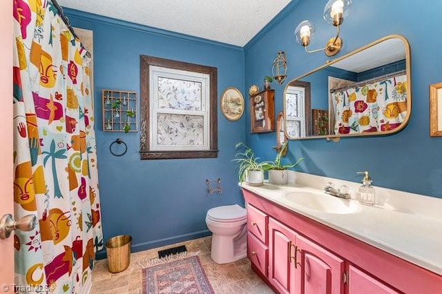 bathroom featuring toilet, vanity, a textured ceiling, and crown molding