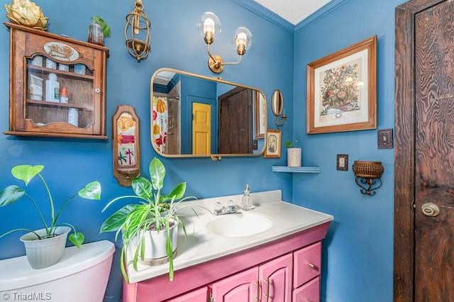 bathroom with vanity, toilet, and crown molding