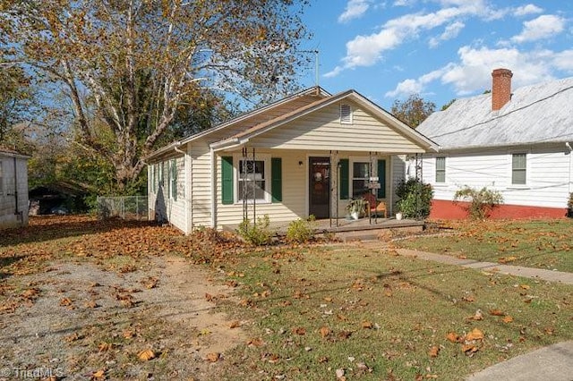 bungalow-style home featuring a front lawn and covered porch