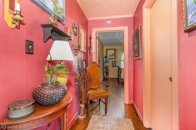 corridor with dark wood-type flooring and crown molding