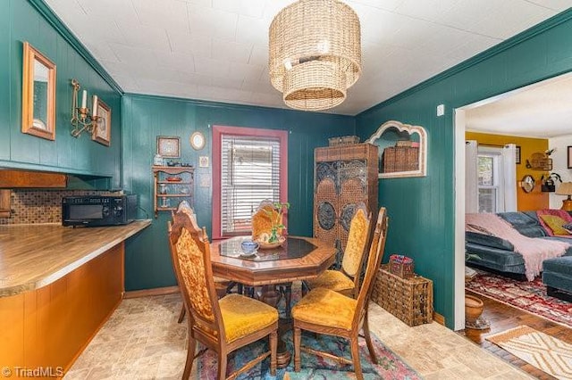 dining area featuring ornamental molding, an inviting chandelier, and a healthy amount of sunlight