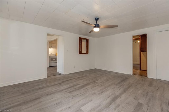 empty room with wood finished floors, baseboards, and ceiling fan