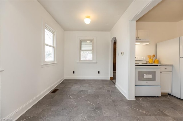 interior space featuring arched walkways, visible vents, marble finish floor, and baseboards