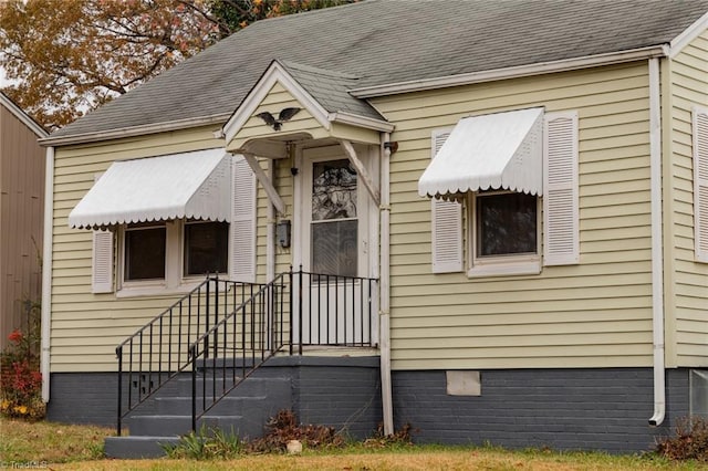 view of front of property with roof with shingles and crawl space