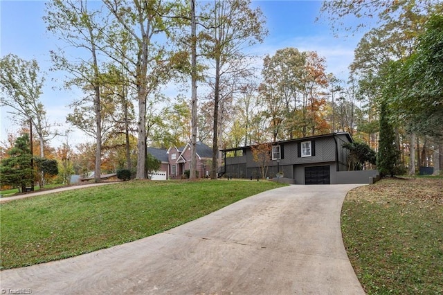 view of front of property featuring concrete driveway, a front lawn, and an attached garage