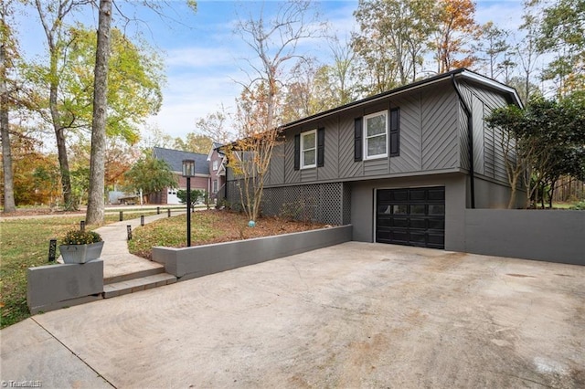 view of side of property featuring driveway, a garage, and stucco siding