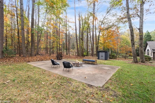 view of yard with a storage shed, an outdoor fire pit, a patio area, and an outdoor structure