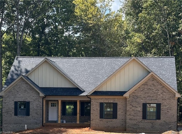 4381 Continental Dr, Pfafftown, NC 27040 - view of front of property with roof with shingles, brick siding, board and batten siding, and covered porch