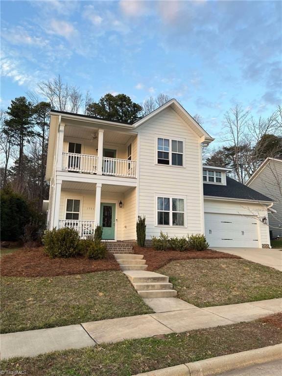 view of front of property featuring a garage, a balcony, and a front lawn