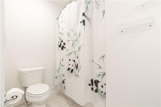 bathroom with tile patterned flooring, walk in shower, and toilet