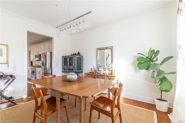 dining area with crown molding and light wood-type flooring