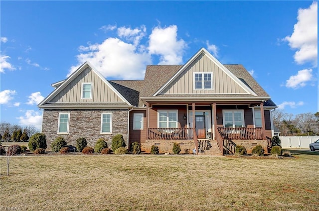 craftsman-style home with covered porch, roof with shingles, a front lawn, and board and batten siding