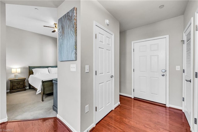 interior space featuring a ceiling fan, baseboards, and wood finished floors