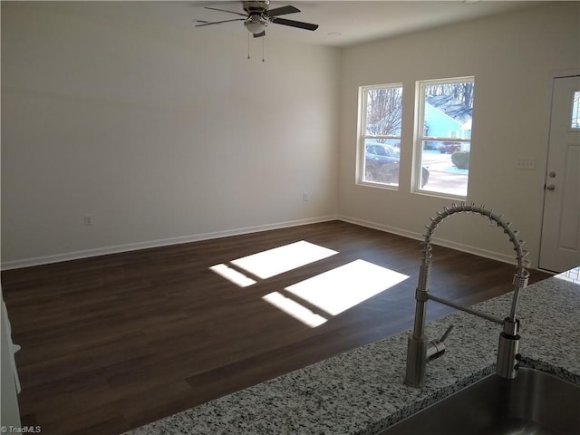 empty room with ceiling fan, dark wood-type flooring, and sink