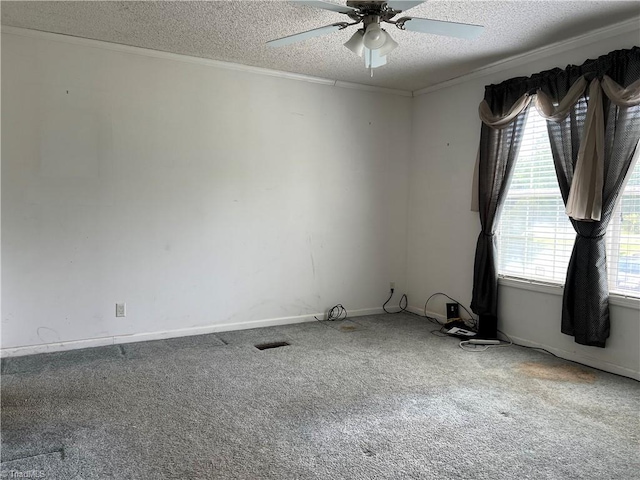 carpeted spare room featuring ornamental molding, a textured ceiling, and ceiling fan