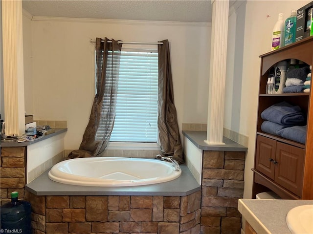 bathroom with vanity, tiled tub, and a textured ceiling