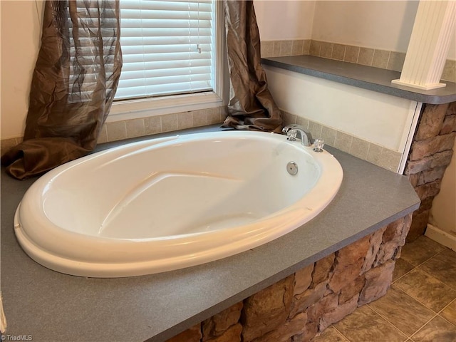 bathroom with tile patterned floors and a bath