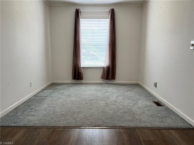 spare room featuring hardwood / wood-style flooring and ornamental molding