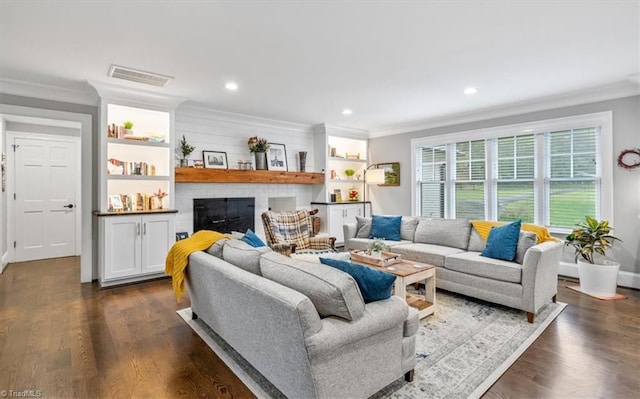 living room with ornamental molding, a brick fireplace, and dark hardwood / wood-style floors