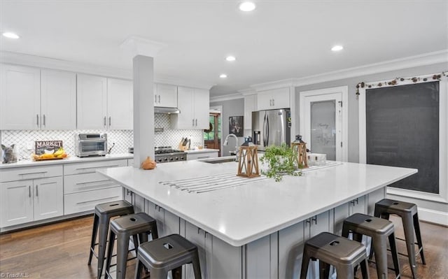 kitchen with a spacious island, stainless steel fridge, and a kitchen breakfast bar