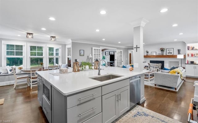 kitchen with a center island with sink, dark hardwood / wood-style flooring, stainless steel dishwasher, gray cabinetry, and sink